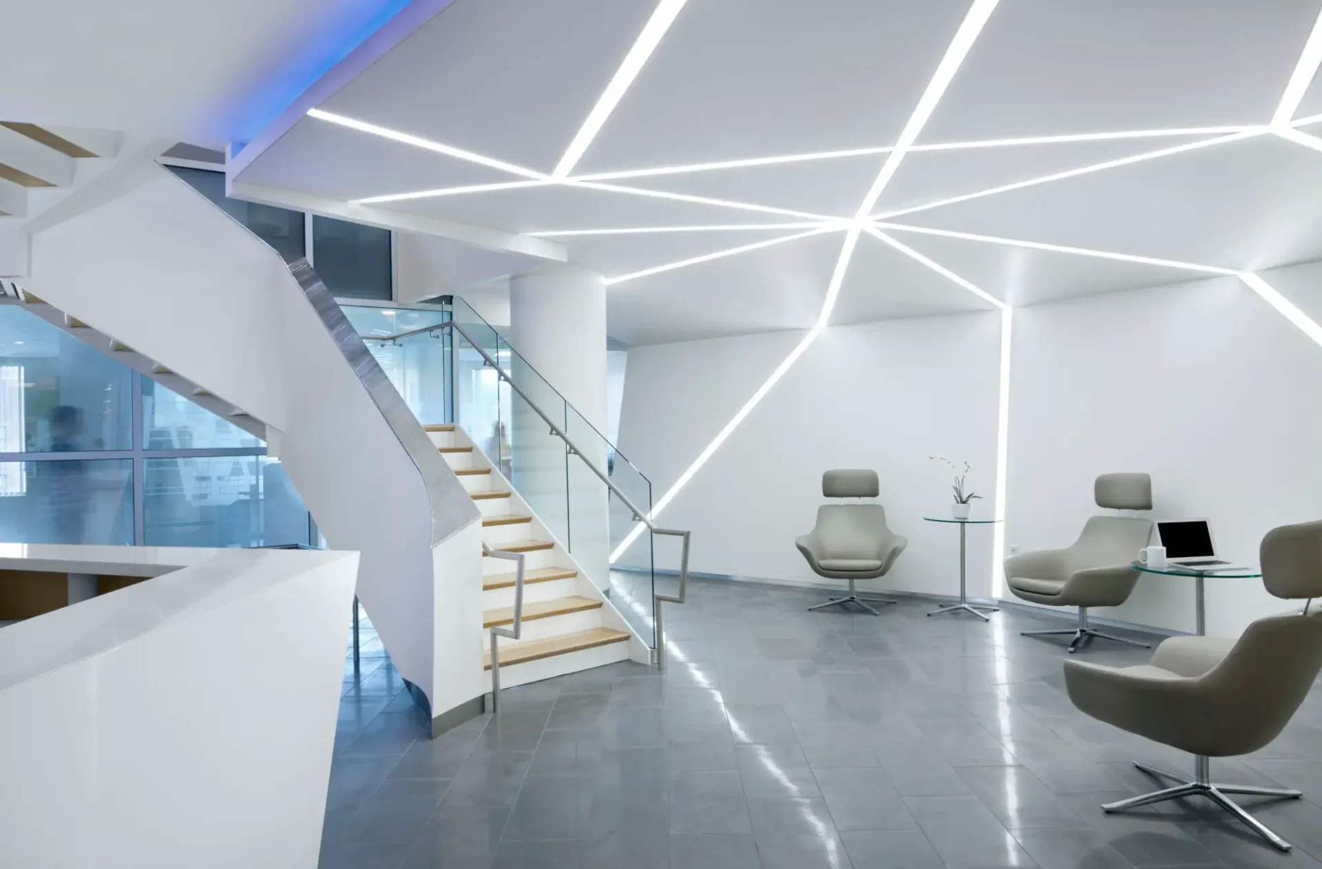 A modern looking lobby with stairs and lights.